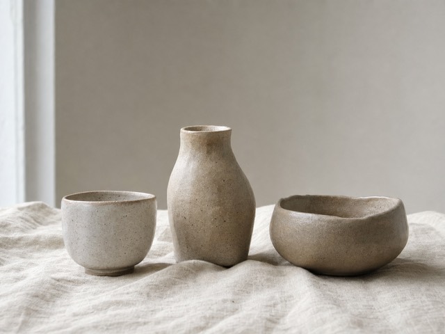 Three stoneware vessels on linen